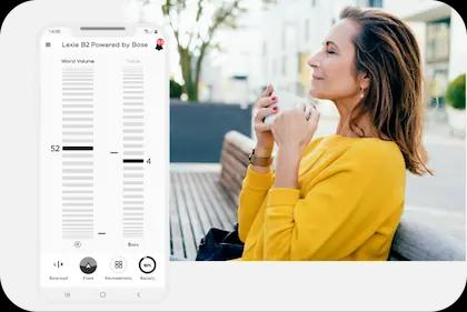 A screenshot of the Lexie Hearing App's home page. To the right is a woman, in suite, looking at her phone.
