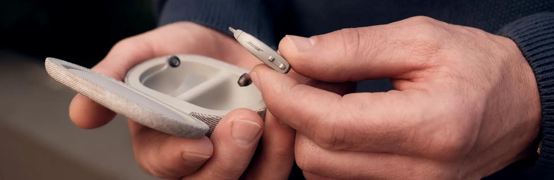 A person holding the Lexie B1 Powered by Bose hearing aids