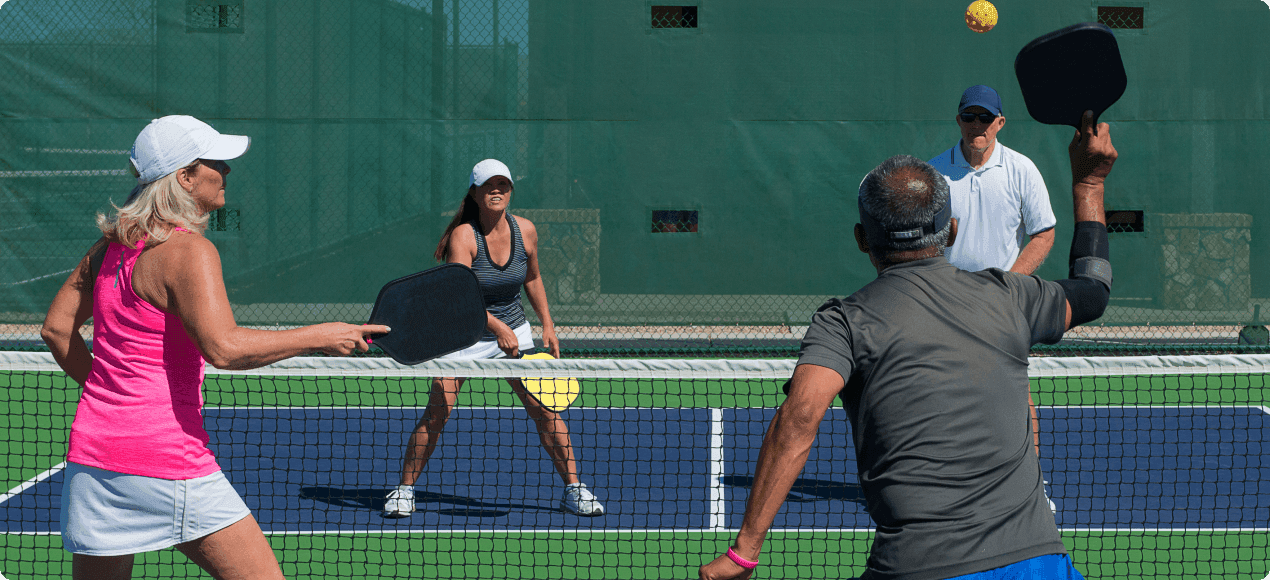 People smiling while playing tennis