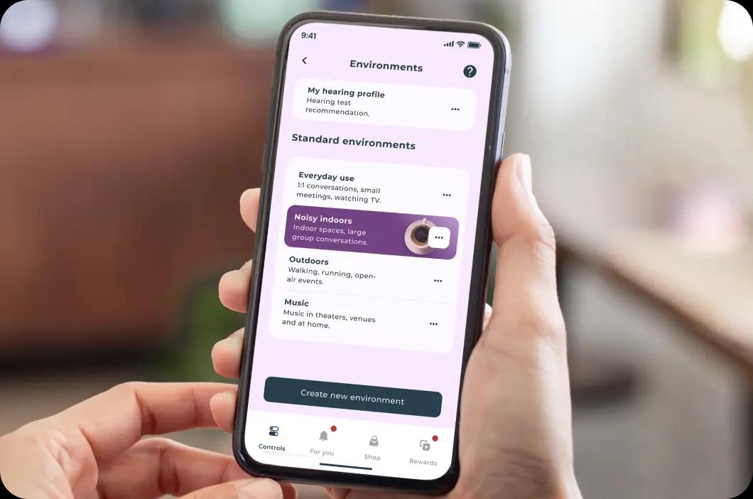 Hand holding a phone, browsing the environments options on the Lexie app.