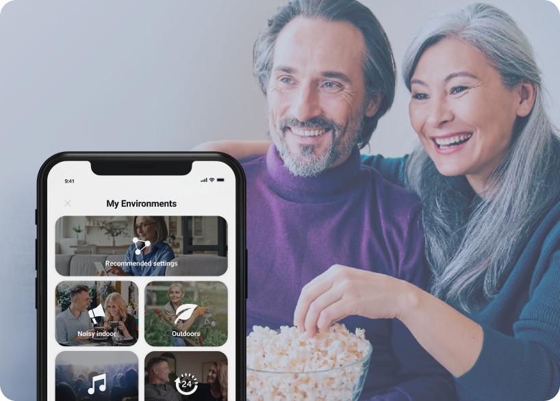 Man and woman watching TV and eating popcorn. 