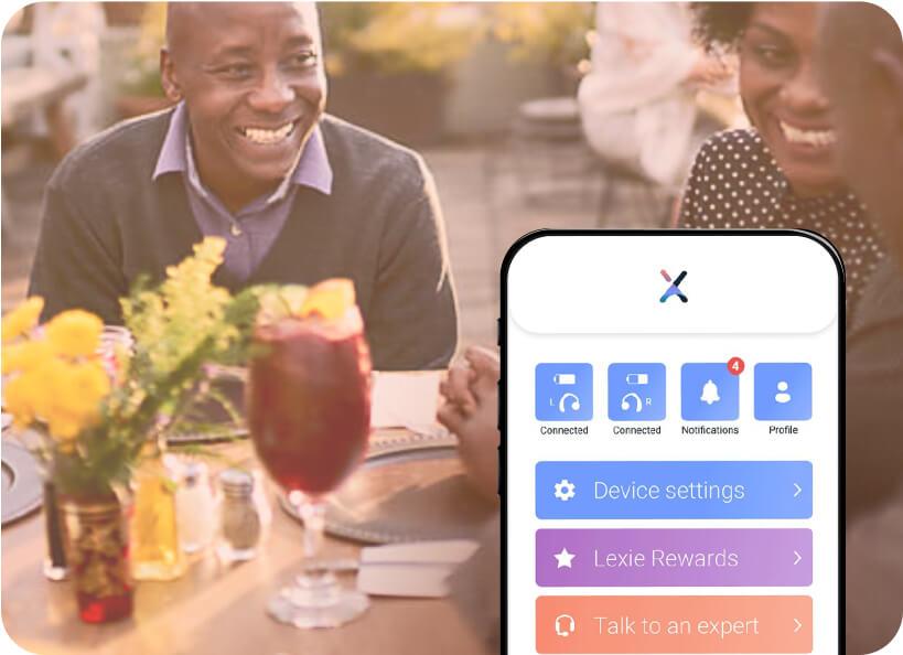 A group of woman eating at a restaurant, one adjusting her Lexie hearing aids on the Lexie app.