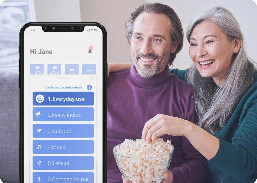 Man and woman watching TV and eating popcorn. 