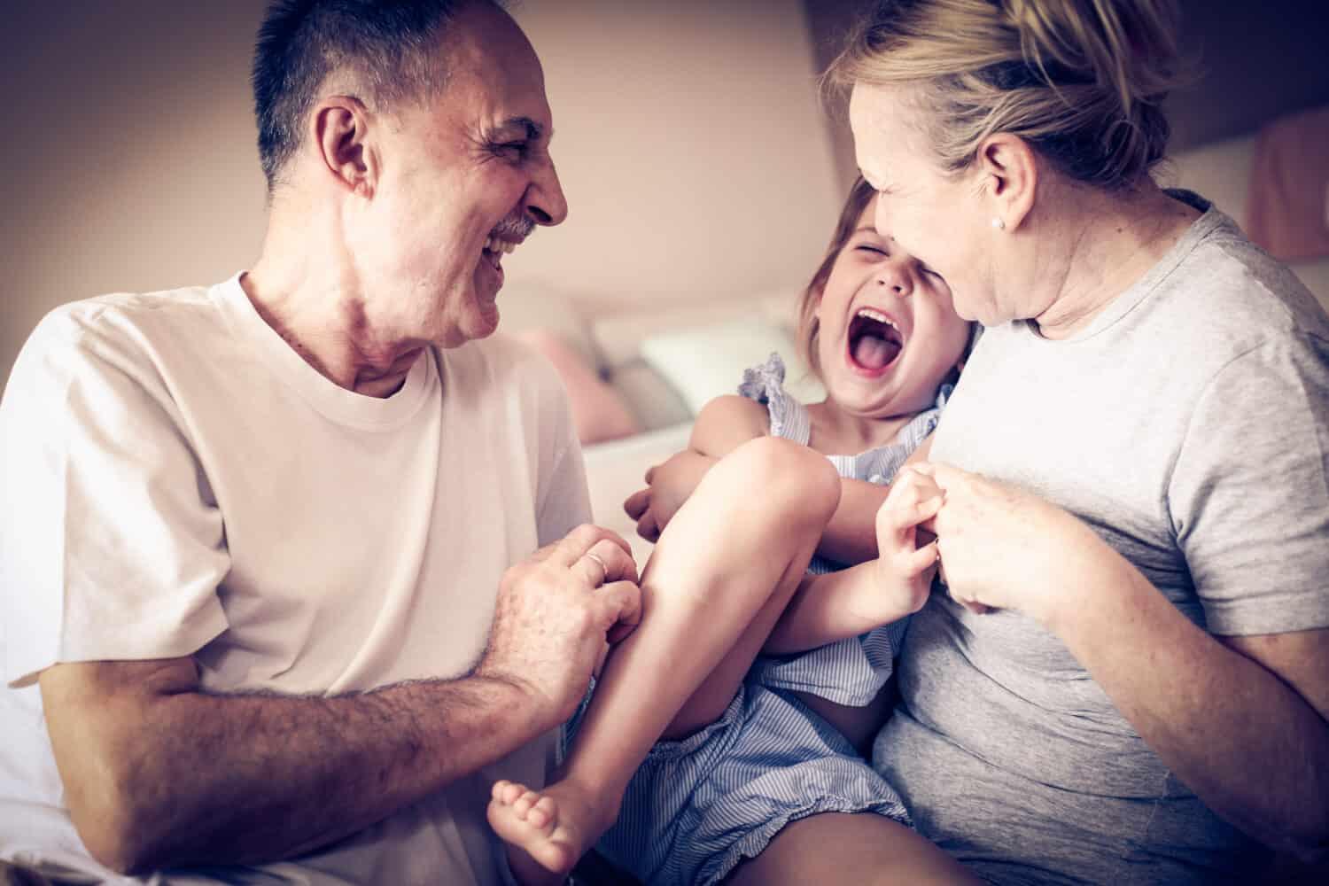 Grandparents with mild hearing loss playing with their granddaughter