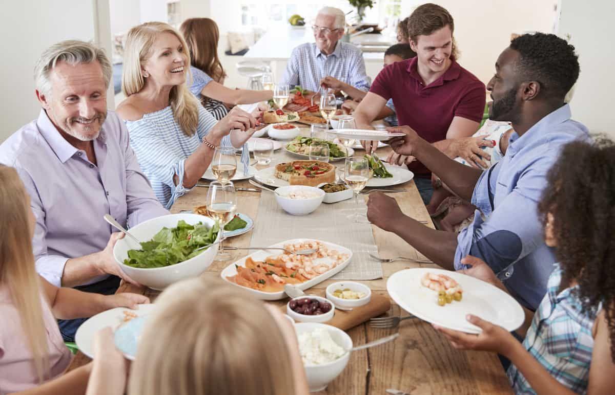 group of people around a dining table having a healthy meal discussing food and hearing health