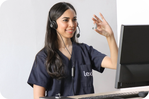 Lexie Expert wearing a headset and holding up a Lexie hearing aid.