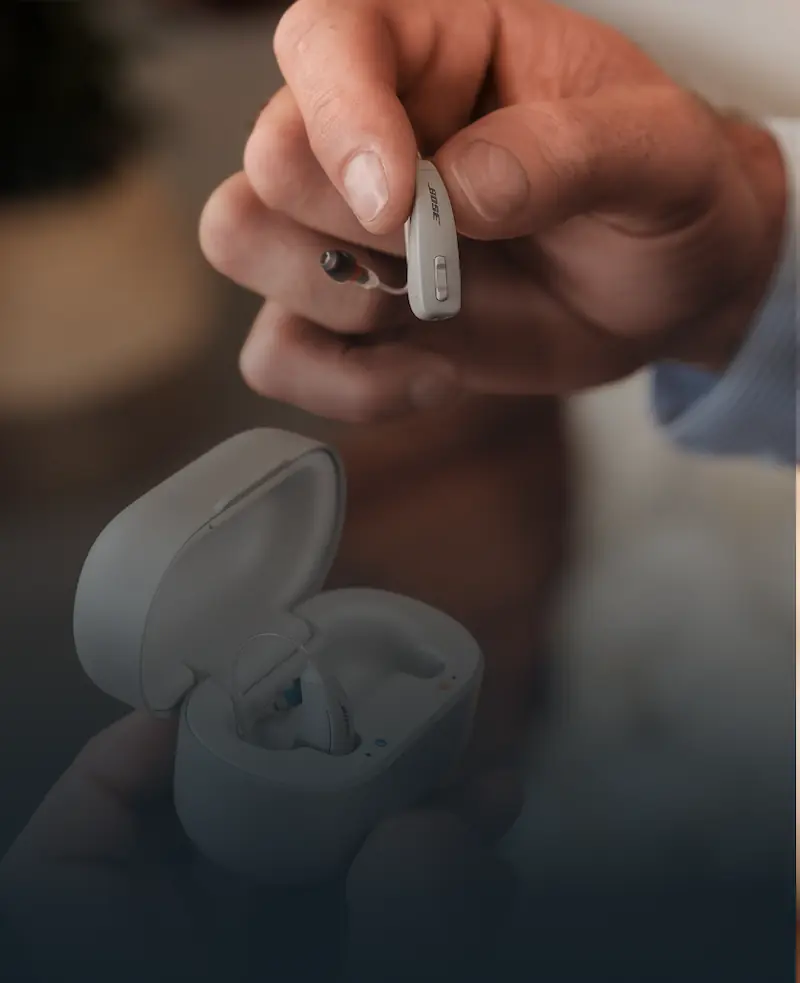 A person holding the Lexie B2 Powered by Bose hearing aids