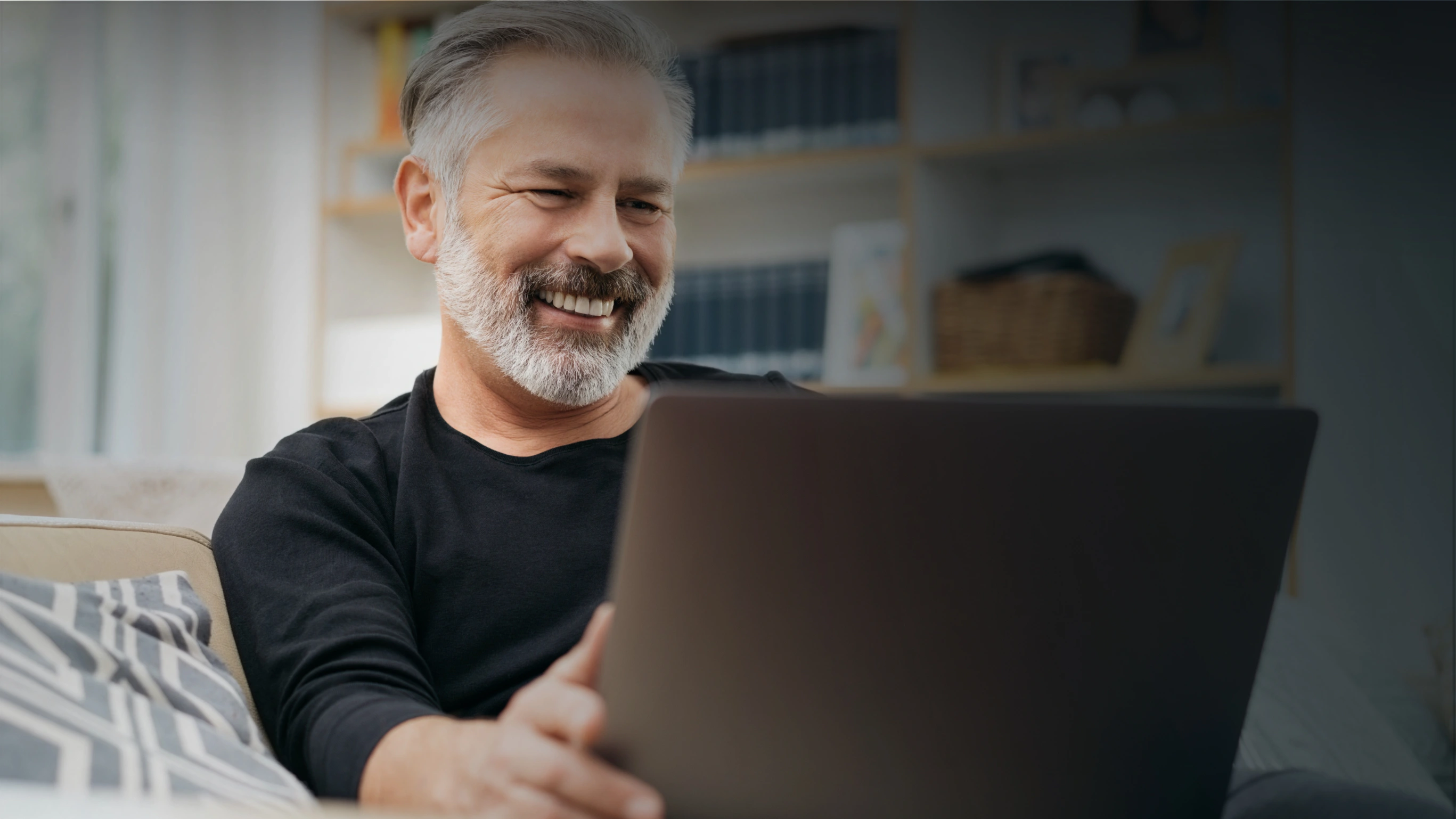 Elderly man smiling with laptop