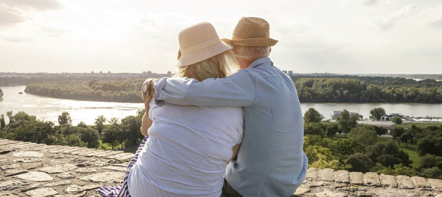 Man and woman sitting on a hilltop and discussing how common hearing loss is