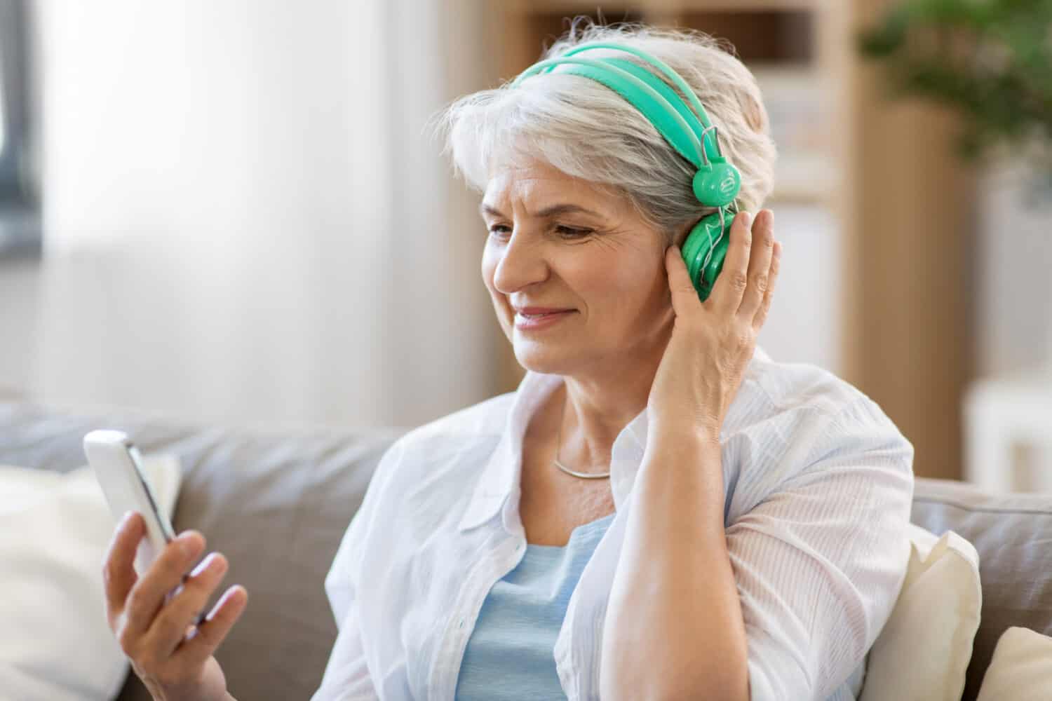 woman wearing green headphones while researching the best online hearing test