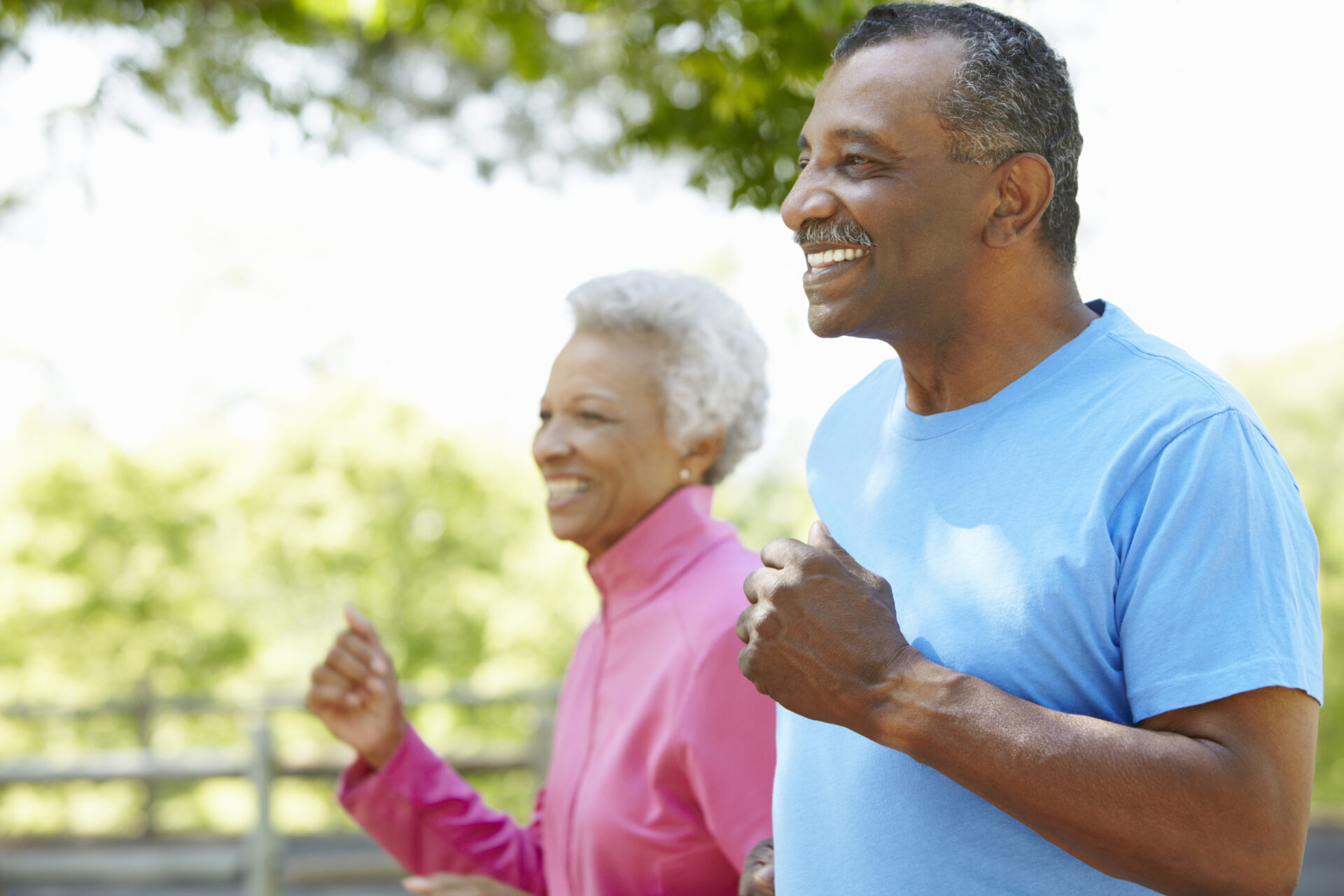 Senior African American Couple Jogging In Park, preventing their lifestyle to influence hearing