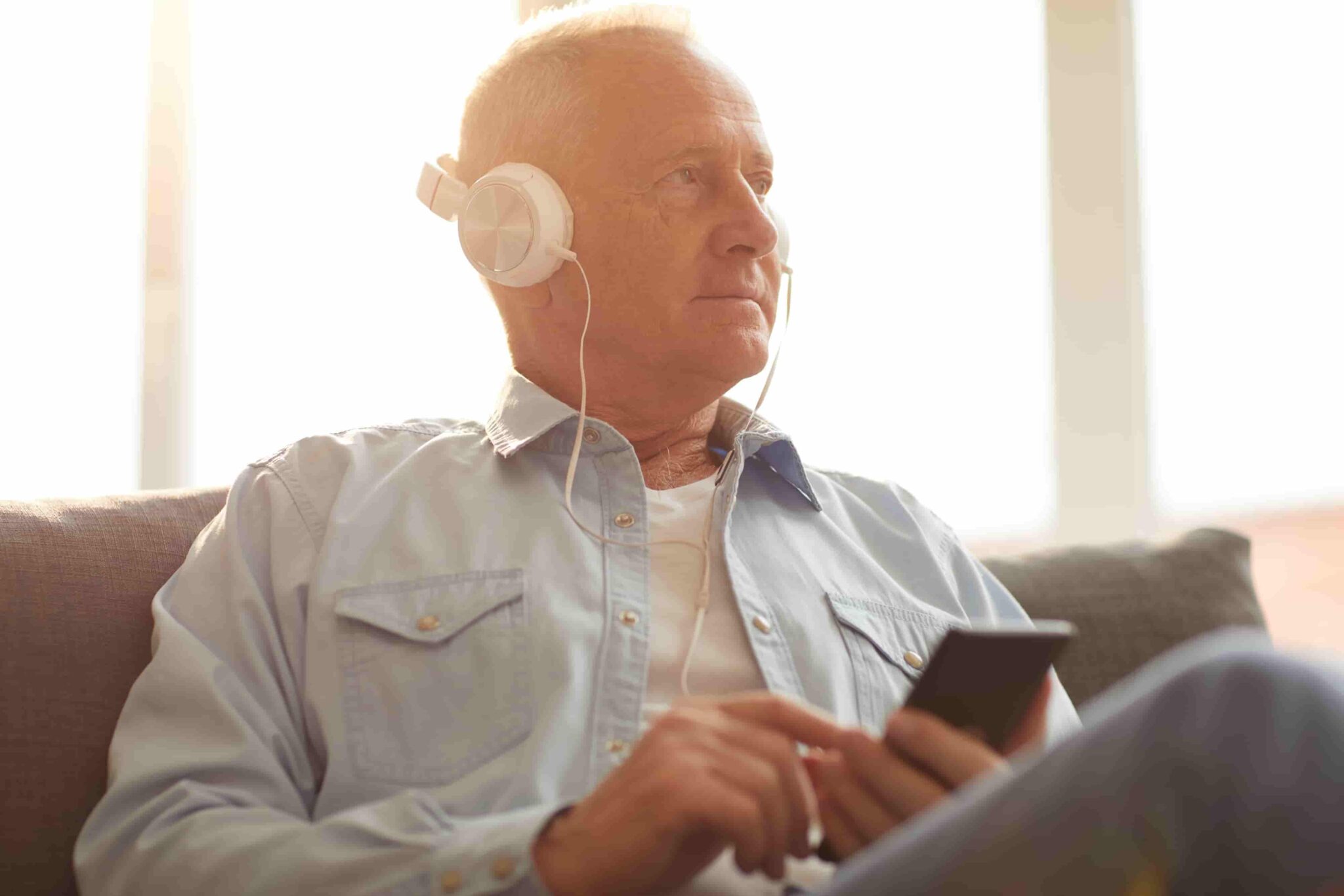 Elderly man using headphones to listen to music
