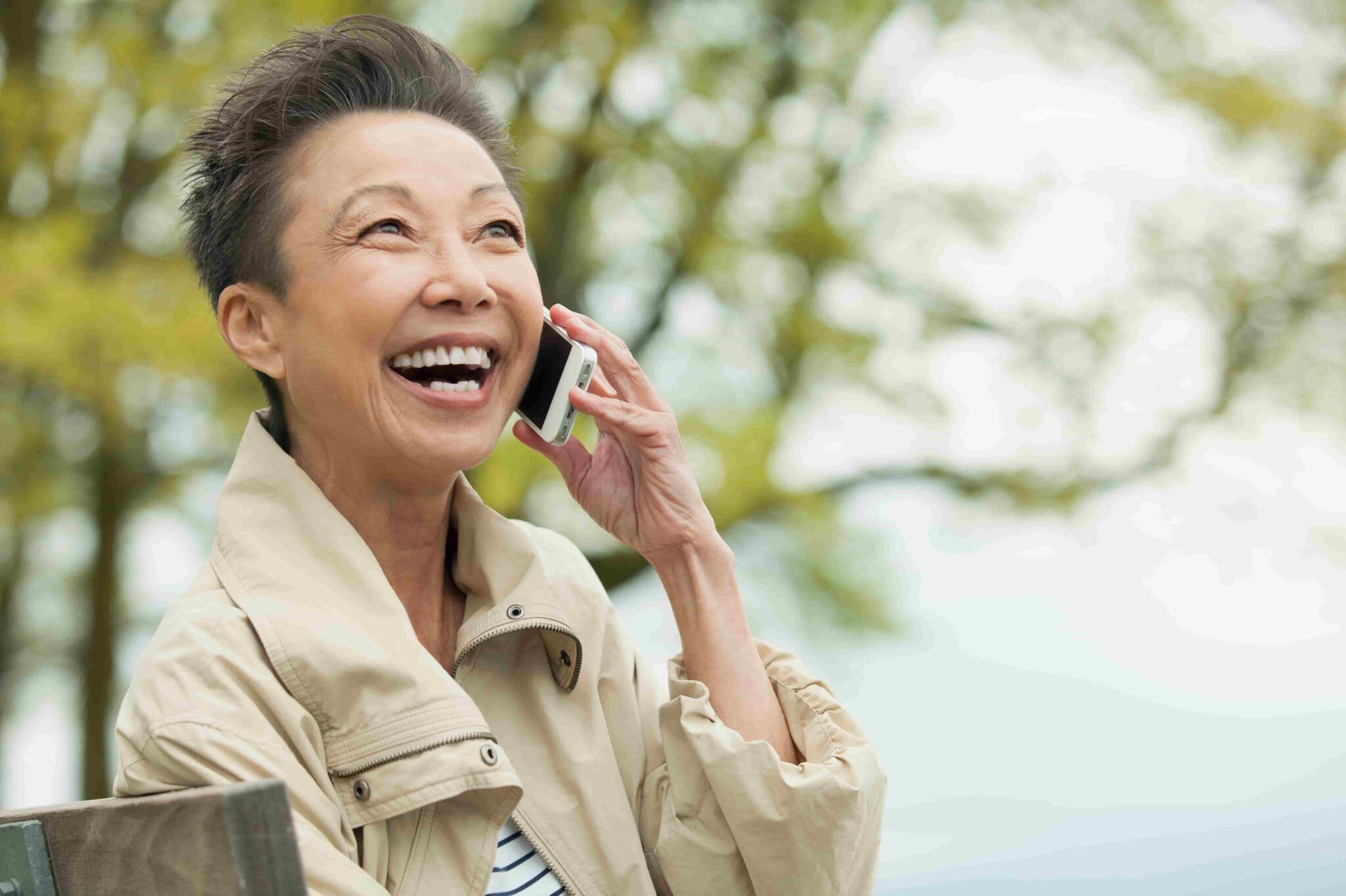 Middle-aged woman sitting outside while speaking on her cellphone