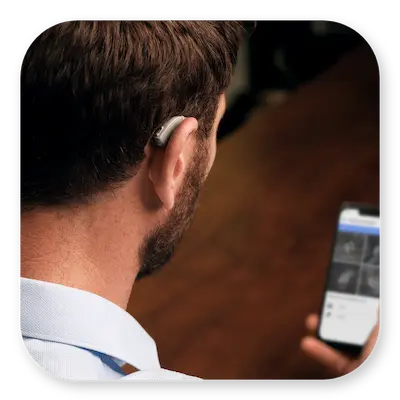 Lexie B1 Lifestyle | Single hearing aid behind ear with app on a smartphone thumbnail