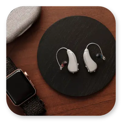 Lexie B1 Lifestyle | Hearing aids lying on a table with carry case and watch next to them thumbnail