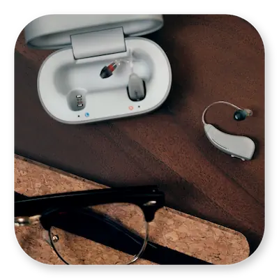 Lexie B2 Lifestyle | One hearing aid lying on table with carry case next to it thumbnail
