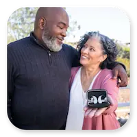 Lexie Lumen Lifestyle | Couple holding the Lexie Lumen hearing aids in their case thumbnail.