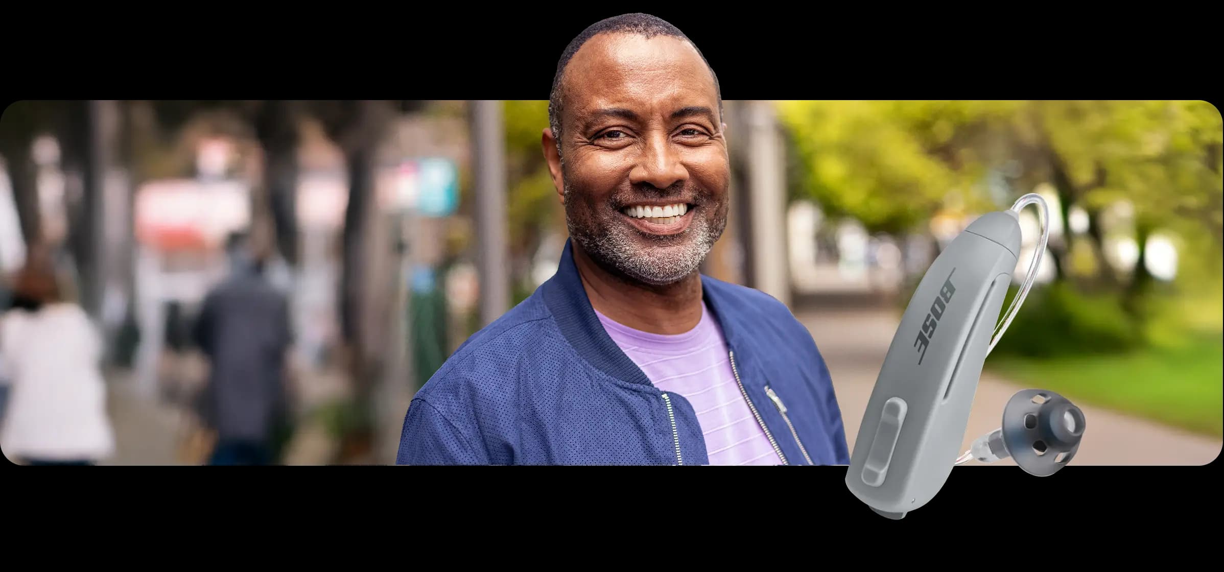 Smiling man and a Lexie B2 Plus Powered by Bose hearing aid